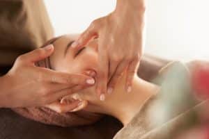 Japanese woman receiving a facial massage at an aesthetic salon